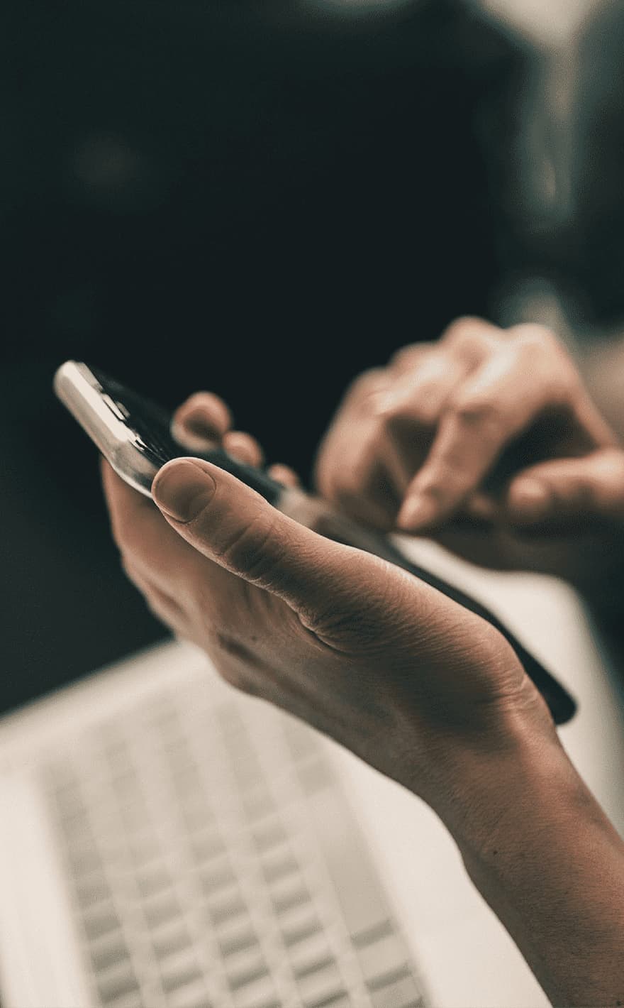 Hands holding a phone while dialing a number